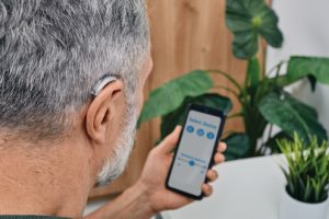 620x330_Hearing-impaired-man-adjusts-settings-for-his-BTE-hearing-aid-via-smartphone_shutterstock_2105518481-300x200.jpg